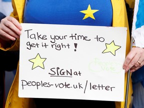 A demonstrator holds a placard during a protest outside the Court of Sessions, where a hearing is taking place to force Britain's Prime Minster Boris Johnson to seek a delay to Brexit, in Edinburgh, October 21, 2019. (REUTERS/Russell Cheyne)