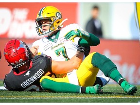 Trevor Harris of the Edmonton Eskimos is tackled by Cory Greenwood of the Calgary Stampeders during CFL football action in Calgary on Monday, September 2, 2019. Al Charest/Postmedia