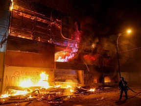 A fireman works to put out fire at a supermarket during a protest against the government in Valparaiso, Chile October 19, 2019.