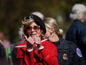 Actor and activist Jane Fonda gives a thumbs up in handcuffs as she is detained for blocking the street in front of the Library of Congress during the "Fire Drill Fridays" protest in Washington, U.S., October 18, 2019.