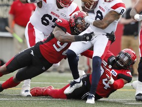 Montreal Alouettes quarterback Vernon Adams Jr., top right, is tackled by Calgary Stampeders players Chris Casher, left, and Da'Sean Downey during first half CFL football action in Calgary on August 17, 2019. While there's no love lost between the Alouettes and Stampeders, neither team is looking for a repeat of last game's fireworks. A heated contest between Montreal and Calgary in mid-August started with a pre-game brawl and ended with a dramatic come-from-behind overtime victory by the Alouettes. That wild finish - and the bad blood between both teams - is still fresh on everyone's minds as the Als (7-6) prepare to host the Stamps (9-4) in a rematch on Saturday afternoon. THE CANADIAN PRESS/Larry MacDougal