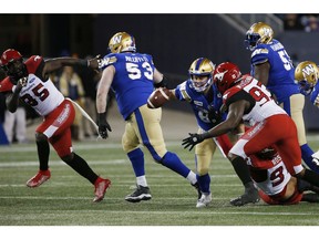CP-Web.  Winnipeg Blue Bombers quarterback Zach Collaros (8) tosses the ball away to a receiver before he is tackled by Calgary Stampeders' Jabar Westerman (93) during the first half of CFL action in Winnipeg Friday, October 25, 2019.