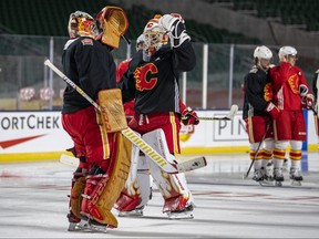 Calgary Flames' goaltenders David Rittich (33), left, and Cam Talbot (39) high five during practice for the NHL Heritage Classic outdoor hockey game in Regina,Friday,October 25,2019. THE CANADIAN PRESS/Liam Richards