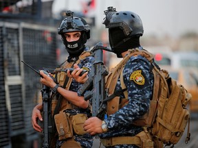 Members of Iraqi federal police are seen with military vehicles in a street in Baghdad, Iraq October 7, 2019. (REUTERS/Wissm al-Okili)