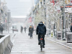 A cyclist heads down a snowy Stephen Avenue in downtown Calgary on Tuesday, Oct. 8, 2019.