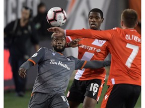 Forge FC defender Chris Nanco (11) looks to play the ball against Cavalry FC midfielder Elijah Adekugbe (16) and forward Oliver Minatel (7) in the second half of a Canadian Premier League soccer match at Tim Hortons Field on Wednesday night. Photo by Dan Hamilton/USA TODAY Sports.