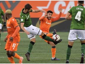 Forge FC midfielder Tristan Borges (19, right) commits a foul that earns him a red card against Cavalry FC defender Jonathan Wheeldon (14) in the second half of a Canadian Premier League soccer final match at Tim Hortons Field.