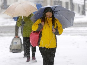 Pedestrians navigate ice and snow in Calgary on Sunday, Sept. 29, 2019.