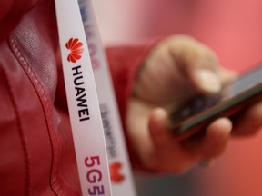 An attendee wears a badge strip with the logo of Huawei and a sign for 5G at the World 5G Exhibition in Beijing, China Nov. 22, 2019. (REUTERS/Jason Lee/File Photo)