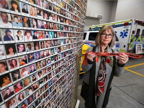 Denise Dubyk with MADD Calgary stands next to a memorial wall to Canadian victims of impaired drivers at the launch of the annual Project Red Ribbon campaign to prevent impaired driving over the holiday season.