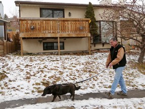 Chris Wentworth walks his dog Lucy past a house at 1040 Ranchlands Blvd. N.W. the morning after 7 dogs died in a smoky fire in the home Monday night, November 11, 2019. Wentworth who lives nearby was saddened to hear so many dogs had died. Gavin Young/Postmedia