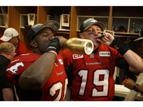 Brandon Smith and quarterback Bo Levi Mitchell of the Calgary Stampeders celebrate their team's win in the 102nd Grey Cup in their locker room at BC Place in Vancouver on Sunday, Nov. 30, 2014. The Calgary Stampeders beat the Hamilton Tiger-Cats in the CFL championship game 20-16. File photo by Ian Kucerak/Postmedia.