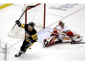 CP-Web.  Pittsburgh Penguins' Jake Guentzel (59) celebrates after beating Calgary Flames goaltender David Rittich (33) with his game-winning overtime goal during an NHL hockey game in Pittsburgh, Monday, Nov. 25, 2019. The Penguins won 3-2.