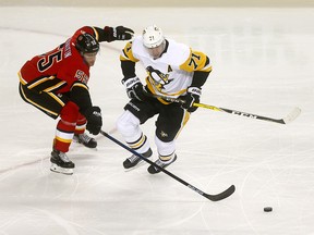 Calgary Flames, Noah Hanifin battles Pittsburgh Penguins, Evgeni Malkin in first period action at the Scotiabank Saddledome in Calgary on Thursday October 25, 2018. Darren Makowichuk/Postmedia