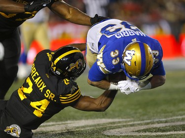 Winnipeg Blue Bombers, Andrew Harris  is taken down by the Hamilton Tiger-Cats, Delvin Breaux at McMahon stadium during the 107th Grey Cup in Calgary on Sunday, November 24, 2019. Darren Makowichuk/Postmedia