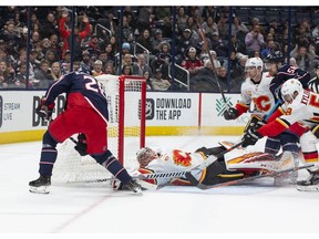Calgary Flames goaltender David Rittich (33) dives to block a shot from Columbus Blue Jackets right wing Oliver Bjorkstrand (28) during the game at Nationwide Arena on Saturday night. Photo by Jason Mowry/USA TODAY Sports.