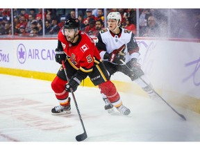 Nov 5, 2019; Calgary, Alberta, CAN; Calgary Flames defenseman Mark Giordano (5) and Arizona Coyotes left wing Christian Dvorak (18) battle for the puck during the second period at Scotiabank Saddledome. Mandatory Credit: Sergei Belski-USA TODAY Sports ORG XMIT: USATSI-405224