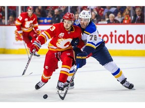 Nov 9, 2019; Calgary, Alberta, CAN; Calgary Flames left wing Johnny Gaudreau (13) and St. Louis Blues defenceman Justin Faulk (72) battle for the puck during the first period at Scotiabank Saddledome. Mandatory Credit: Sergei Belski-USA TODAY Sports ORG XMIT: USATSI-405254