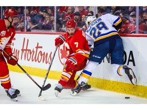 Nov 9, 2019; Calgary, Alberta, CAN; Calgary Flames defenseman TJ Brodie (7) and St. Louis Blues left wing Mackenzie MacEachern (28) battle for the puck during the second period at Scotiabank Saddledome. Mandatory Credit: Sergei Belski-USA TODAY Sports ORG XMIT: USATSI-405254