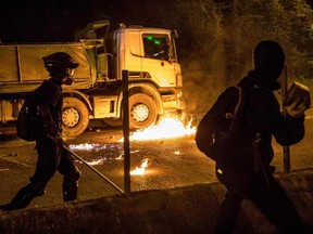 A molotov cocktail thrown by a protester burns next to a truck after the driver attempted to drive through a blocked road outside the Hong Kong Polytechnic University, in Hong Kong, China, on Thursday, Nov. 14, 2019.