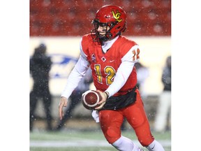 Calgary Dinos quarterback Adam Sinagra prepares a hand off in the backfield during U Sports Canadian college football action between the University of Calgary Dinos and the Manitoba Bisons in Calgary on Friday, October 12, 2018. Jim Wells/Postmedia