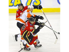 Calgary Flames Rasmus Andersson battles Philadelphia Flyers Scott Laughton in third period NHL action at the Scotiabank Saddledome in Calgary on Tuesday, October 15, 2019. Darren Makowichuk/Postmedia