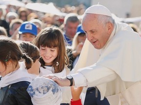 Pope Francis blesses a child as he arrives for the general audience at the Vatican, October 9, 2019.