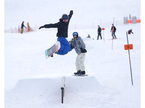 Snowboarders get some airtime at WinSport in Calgary on Wednesday. Photo by Darren Makowichuk/Postmedia.