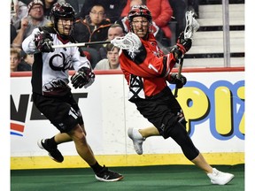 Calgary Roughnecks Tyler Burton fights for the possession of the ball with Colorado Mammoths Brett Craig during the home opener game in Scotiabank Saddledome on Saturday, December 21, 2019. Azin Ghaffari/Postmedia
