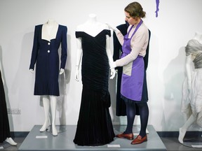 An assistant poses with Britain's Princess Diana's Victor Edelstein midnight-blue velvet evening gown (estimated at 250,000 - 350,000 pounds), which was worn by the princess when she danced with actor John Travolta at the White House in 1985. (REUTERS/Henry Nicholls)