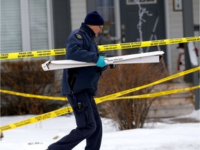 RCMP and ASIRT take a rifle away as they investigate a fatal shooting by a RCMP member in Cochrane on Saturday, December 7, 2019.