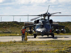A man stands next to the Black Hawk helicopter that searched for the Chilean Air Force C-130 Hercules cargo plane that went missing with 38 people aboard, at Chabunco army base in Punta Arenas, Chile, on December 11, 2019. (PABLO COZZAGLIO/AFP via Getty Images)