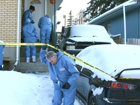 Calgary Police Crime Scene Unit and a member of the Medical Examiner's office enter a duplex in the 400 block of 28 Ave. N.E. in Calgary on Sunday. Police are investigating a suspicious death of a man in his 50s in the house. Photo by Jim Wells/Postmedia.