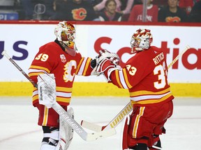 Flames goaltenders Cam Talbot (L) and David Rittich exchange pleasantries after Canucks third goal and Rittich was pulled during NHL action between the Calgary Flames and the Vancouver Canucks in Calgary on Sunday, December 29, 2019. Jim Wells/Postmedia