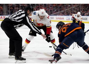 The Edmonton Oilers' Ryan Nugent-Hopkins takes a face-off against the Calgary Flames' Milan Lucic during first-period NHL action at Rogers Place, in Edmonton Friday. Photo by David Bloom/Postmedia.