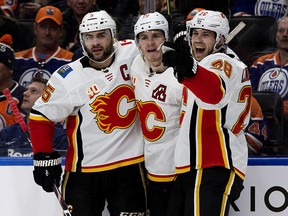 Calgary Flames Mark Giordano, Matthew Tkachuk and Elias Lindholm celebrate a goal against the Edmonton Oilers in the first period at Rogers Place in Edmonton on Friday, Dec. 27, 2019.