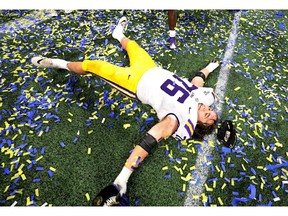 Dec 7, 2019; Atlanta, GA, USA; LSU Tigers offensive lineman Austin Deculus (76) does a snow angel in confetti after their win against the Georgia Bulldogs in the 2019 SEC Championship Game at Mercedes-Benz Stadium. Mandatory Credit: Jason Getz-USA TODAY Sports     TPX IMAGES OF THE DAY ORG XMIT: USATSI-419478