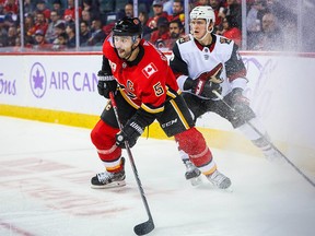 Nov 5, 2019; Calgary, Alberta, CAN; Calgary Flames defenseman Mark Giordano (5) and Arizona Coyotes left wing Christian Dvorak (18) battle for the puck during the second period at Scotiabank Saddledome. Mandatory Credit: Sergei Belski-USA TODAY Sports ORG XMIT: USATSI-405224
