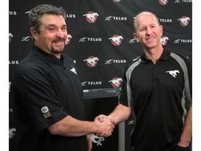 Calgary Stampeders head coach Dave Dickenson, right, shakes hands with Pat DelMonaco after announcing his promotion to offensive coordinator and offensive line coach on Thursday December 12, 2019.  Gavin Young/Postmedia
