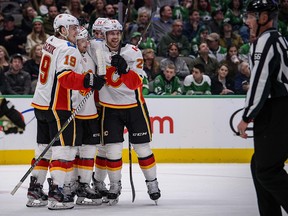 Matthew Tkachuk, left, Andrew Mangiapane and Elias Lindholm celebrate a goal against the Dallas Stars on Dec. 22, 2019.