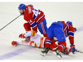 Calgary Flames defenceman Oliver Kylington collides with Nate Thompson and Brett Kulak of the Montreal Canadiens during NHL hockey in Calgary on Thursday December 19, 2019. Al Charest / Postmedia