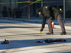 Crime scene investigators place evidence markers at the scene of an early morning suspicious death along 11th Avenue near 1st Street S.W. in Calgary on Sunday, January 5, 2020.