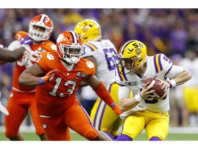 NEW ORLEANS, LOUISIANA - JANUARY 13: Joe Burrow #9 of the LSU Tigers scrambles against Tyler Davis #13 of the Clemson Tigers in the College Football Playoff National Championship game at Mercedes Benz Superdome on January 13, 2020 in New Orleans, Louisiana.