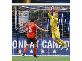 Cavary FC keeper Marco Carducci (R) grabs a ball in the air as defender Mason Trafford looks on during third round CPL Canadian Championships soccer action between Cavalry FC and Vancouver Whitecaps at BC Place in Vancouver, BC  Wednesday, July 24, 2019. Jim Wells/Postmedia