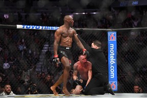 Kamaru Usman (red gloves) reacts as referee Marc Goddard stops his bout against Colby Covington (blue gloves) during UFC 245 at T-Mobile Arena on Dec. 14, 2019.