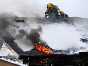 Calgary firefighters attack a fire from the roof of a home on Templeby Drive N.E. on Sunday January 19, 2020.