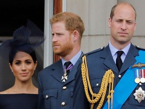 In this file photo taken on July 10, 2018 (L-R) Britain's Meghan, Duchess of Sussex, Britain's Prince Harry, Duke of Sussex, and Britain's Prince William, Duke of Cambridge, stand on the balcony of Buckingham Palace to watch a military fly-past to mark the centenary of the Royal Air Force (RAF).