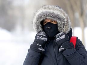 Reta Prasse does her best to stay warm downtown during the deep freeze in Calgary on Tuesday, January 14, 2020. Darren Makowichuk/Postmedia
