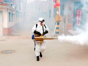 A worker in protective suit disinfects the Dongxinzhuang village, as the country is hit by the new coronavirus, in Qingdao, Shandong, province, China Jan. 29, 2020.
