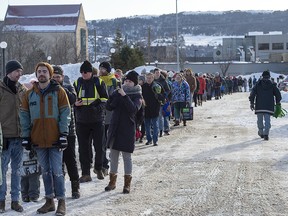 Customers line up at a Sobeys grocery store in St. John's, Nfld., on Tuesday, Jan. 21, 2020. The state of emergency ordered by the city continues, leaving most businesses closed and vehicles off the roads in the aftermath of a major winter storm. Grocery and convenience stores have been allowed to open for limited hours to let residents restock their food supply.